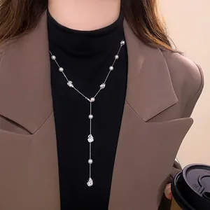 Primo piano dettagliato di elegante collana a Y con perle e perle metalliche su modella