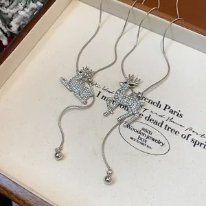 Dettaglio del ciondolo a forma di cervo con strass su una lunga catena d'argento per maglia