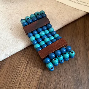 Close-up of multi-layer ethnic bracelet with blue wooden beads and dark wood blocks