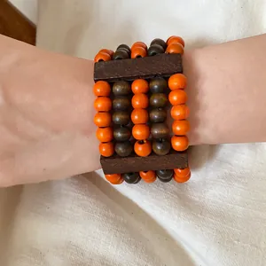 Close-up view of bohemian multi-layer wooden bead bracelet with orange and brown beads