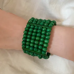 A detailed view of a green multi-layer wooden bead bracelet featuring an ethnic style design