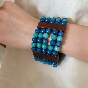 Detail view of a stylish multi-layer wooden beaded bracelet in blue and teal colors.
