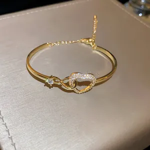 Detailed close-up view of golden hollow heart bracelet with sparkling cubic zirconia accents