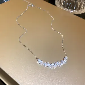 Close-up detail of a silver clavicle necklace with sparkling water drop cubic zirconia stones