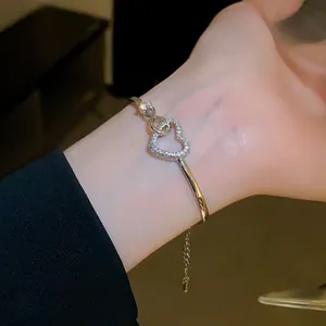 Detailed view of a sparkling heart-shaped silver zircon bangle worn on a model's wrist