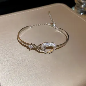 Detailed view of elegant silver-toned heart bangle featuring sparkling zircon stones