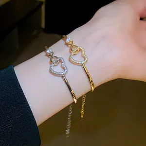 Close-up of gold and silver heart bracelets with sparkling cubic zirconia on wrist