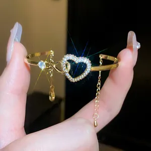 Close-up of elegant gold heart-shaped bangle with sparkling cubic zircon stones