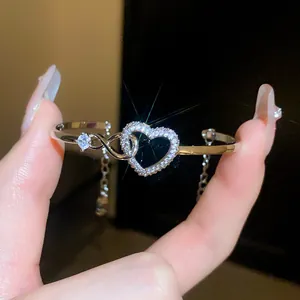 Close-up detail of a silver-tone heart-shaped zircon bracelet with infinity design