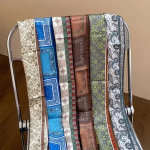 Elegant vintage paisley print silk scarves draped on a modern transparent chair
