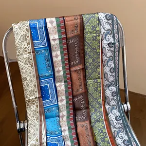 Close-up view of multiple vintage paisley and geometric printed silk skinny scarves
