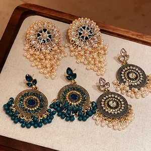 Detailed view of vintage ethnic tassel earrings with pearls and rhinestones on a tray.