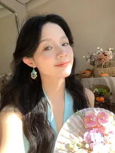 Asian model wearing retro ethnic turquoise pearl drop earrings in a resort setting.