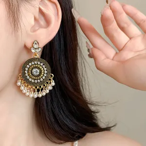 Close-up detail of bohemian style round drop earrings with sparkling crystals and pearls