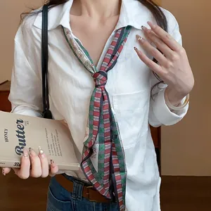 Close-up of a vintage paisley silk scarf necklace paired with a minimalist white shirt