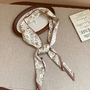 Detail of retro paisley print silk scarf necklace styled on a wooden decorative tray