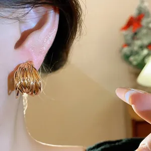 Elegant gold intertwined stud earrings shown on model for a sophisticated aesthetic