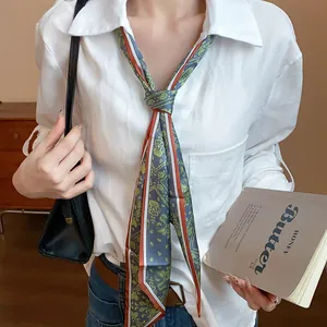 Close-up of vintage green paisley print fabric scarf necklace styled with a white shirt