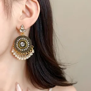 Close-up of vintage ethnic round tassel earrings with white pearls and rhinestones