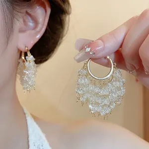 Eleganti orecchini a cerchio placcati oro 18k con frange in cristallo scintillante.