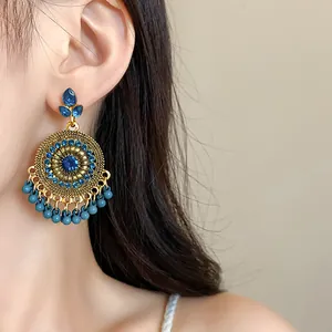 Detailed view of ethnic vintage circular tassel earrings featuring deep blue rhinestones