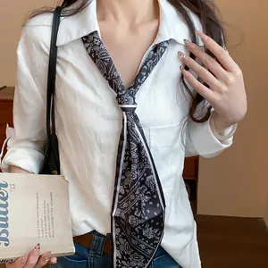 Detailed view of a retro black and white paisley print scarf tied as a necktie accessory