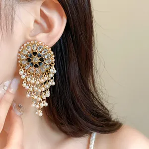 Detailed shot of vintage ethnic style gold-toned earrings with pearls and rhinestones