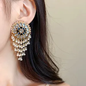 Close-up of ethnic vintage tassel earrings with water-drop rhinestones on model's ear