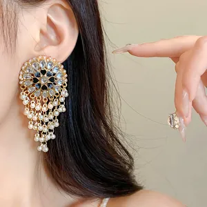 Close-up of vintage ethnic style circular earrings with pearl tassels and rhinestones