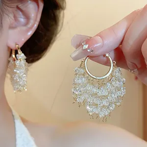 Vista dettagliata di lussuosi orecchini a cerchio placcati oro 18k con nappe di cristallo