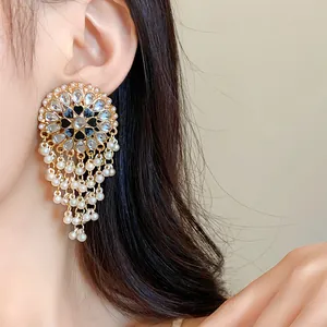 Close-up of vintage round tassel earrings with rhinestones and white pearls