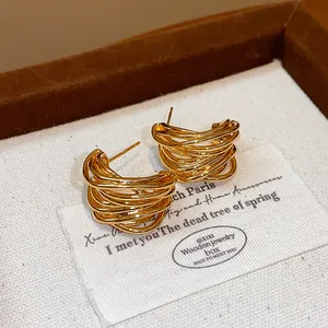Close-up of gold-plated silver needle wound stud earrings in an elegant jewelry box