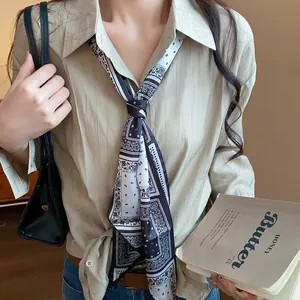 Close-up view of a retro paisley print fabric scarf necklace on a beige shirt