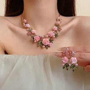 Set collana e orecchini con rose rosa e perle su una modella