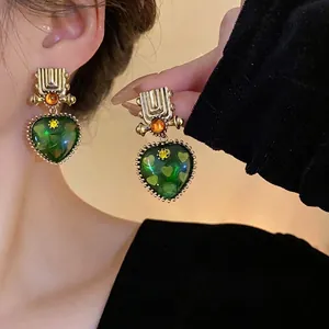 Vintage-style heart-shaped earrings with geometric green pendants and silver needles