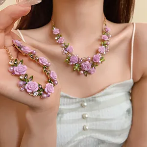 Vista dettagliata di un set collana e bracciale con rose rosa pastorali e perle