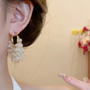 Eleganti orecchini a cerchio placcati oro 18k con nappe di cristallo luccicante.