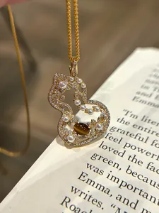 Detailed view of an elegant hollow gourd pendant necklace with pearls and tiger's eye
