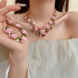 Dettaglio di una collana di rose rosa in stile pastorale con perle e cristalli su una modella
