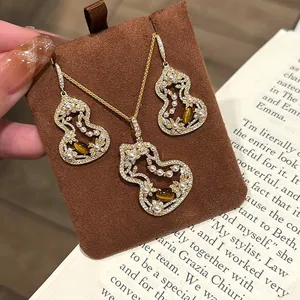 Close-up of hulu hollow-out necklace and earrings set with pearls and tiger-eye stones