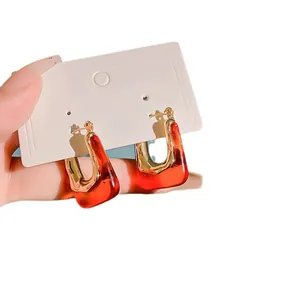 Vintage minimalist U-shaped gold hoop earrings with elegant transparent red resin.