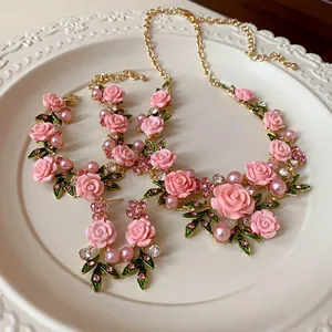 Vista dettagliata di un set di gioielli bucolici con rose rosa, perle e strass