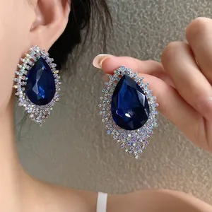 Dramatic silver needle teardrop earrings with deep blue crystal and rhinestone halo