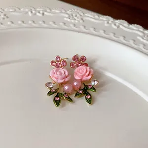 Vista dettagliata di orecchini a rosa rosa in stile pastorale con perle e strass brillanti