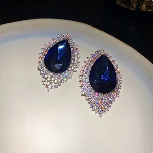 Elegant silver-tone stud earrings featuring large blue teardrop stones and iridescent rhinestones.