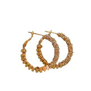 Elegant gold-plated zircon hoop earrings featuring a unique textured metal bead design