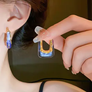 Detailed view of translucent purple U-shaped earrings with gold metal accents