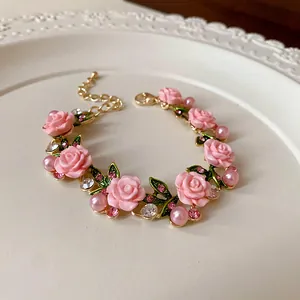 Vista dettagliata di una collana pastorale con rose rosa, perle e strass luccicanti