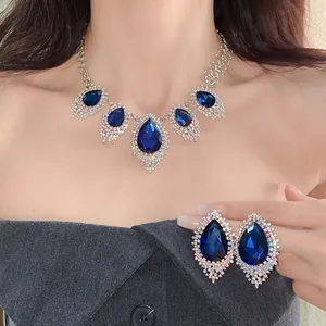 Close-up of elegant blue teardrop rhinestone necklace and earring set on model