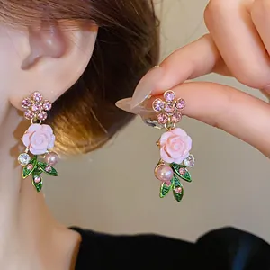 Primo piano di orecchini a rosa rosa pastorali con strass e perle